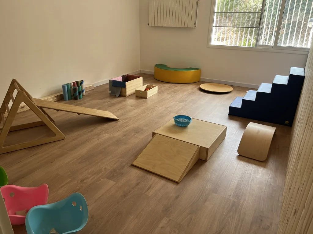 Infants i adults compartint un espai de joc i criança
